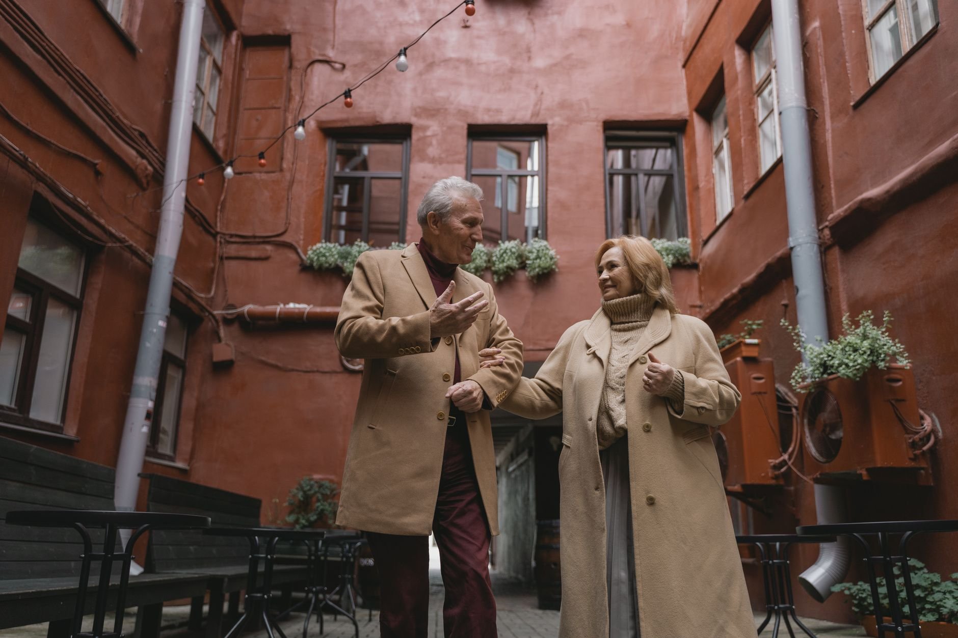 A joyous elderly couple walking hand in hand, sharing a moment together